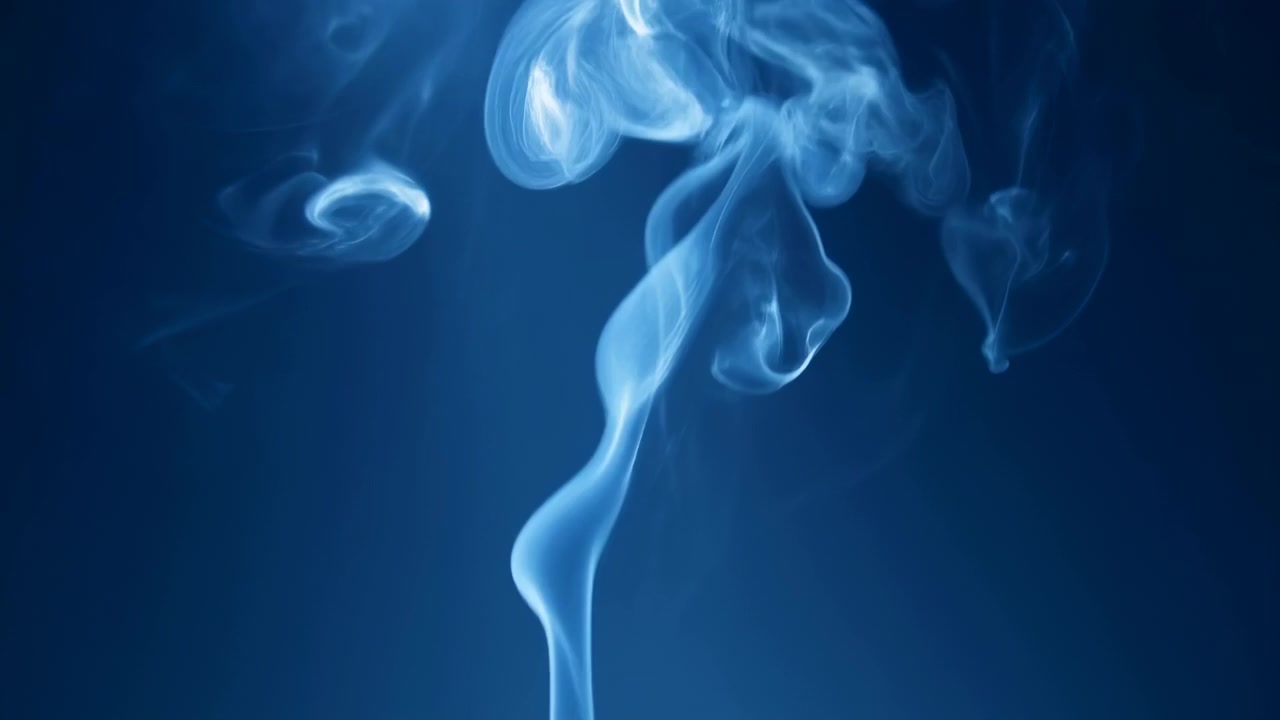 Morbidi filamenti di fumo traslucido si innalzano dal centro inferiore contro uno sfondo sfumato di blu intenso, formando una colonna a forma di fungo con delicate volute