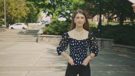 Gorgeous-Caucasian-Woman-In-The-Park-Wearing-Printed-Lace-Blouse-And-Black-Fitted-Pants-Posing-In-Front-Of-The-Camera---Full-Body-Shot