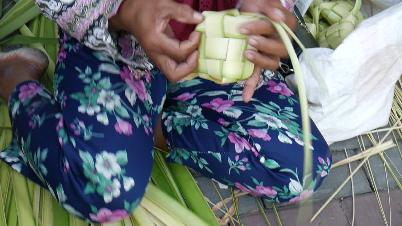인도네시아의 ied fitr 축하 행사에서 제공되는 특별 요리인 케투팟(ketupat)을 만드는 여성 손