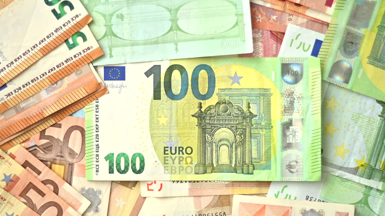 Bir yüzey üzerine dağılmış çok sayıda ellilik ve yüzlük euro banknotun yakın çekimi