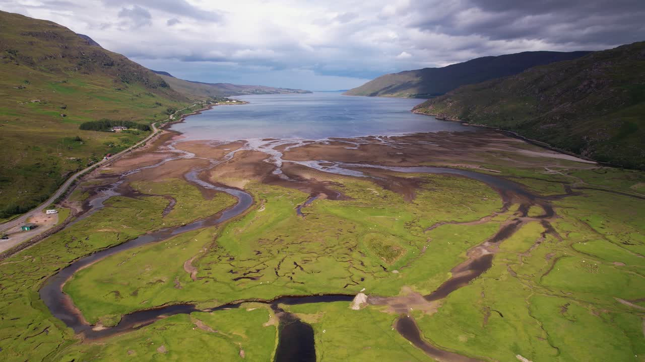una serena vista aérea de una ensenada costera escocesa con exuberante vegetación y ríos sinuosos
