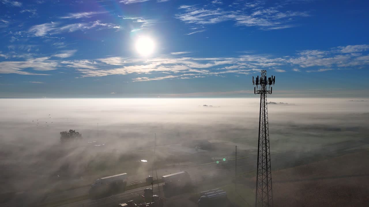 Torre di telecomunicazioni che si erge sopra la nebbia, trasmettendo segnali wireless 5G e 4G, vista aerea