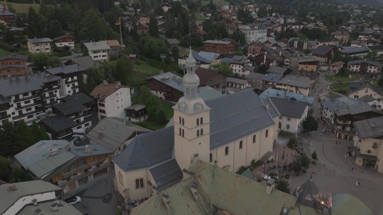 Çarpıcı Fransız Alpleri ile çevrili Megève, Fransa'nın havadan drone çekimi. Alp ormanları, geleneksel dağ evleri, engebeli tepeler ve nefes kesen panoramik manzaralar içeren sinematik dağ manzaraları.