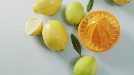 Video-of-fresh-lemons-and-juicer-lying-on-grey-background