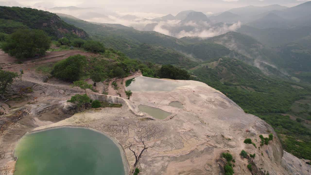 산 위에서 비행기 드론으로  ⁇ 은 물체가 지나가며 울창한 숲을 보여줍니다. 멀리서 산  ⁇  구름이 있습니다.