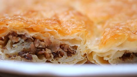 close-up of a delicious, layered pastry with meat filling