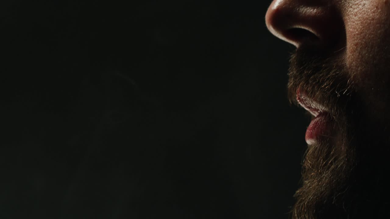 Close-up Profile of Man Exhaling Smoke in Slow Motion