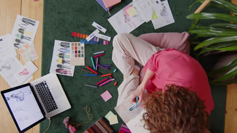 female designer drawing fashion illustrations at home