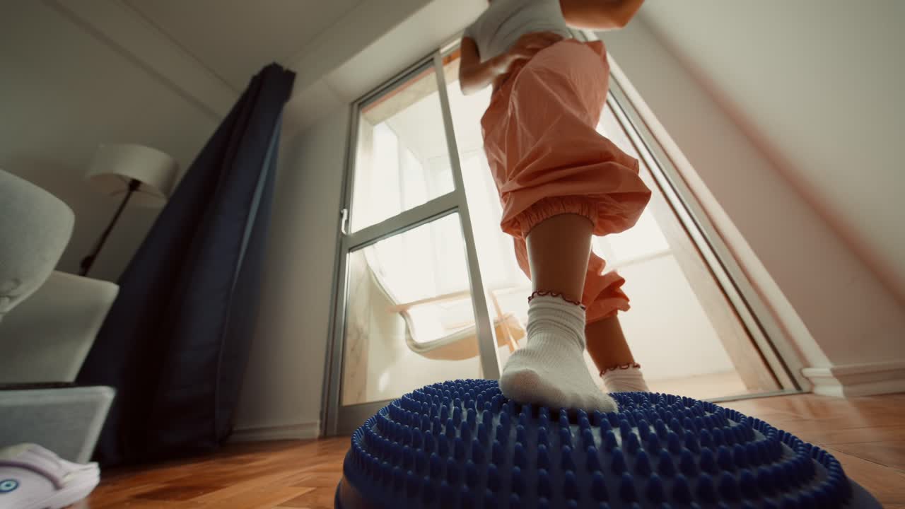Child exercising on a balance board at home