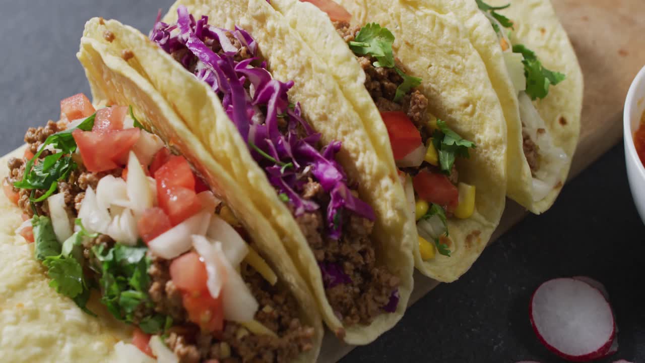 video de tacos recién preparados a bordo sobre un fondo gris