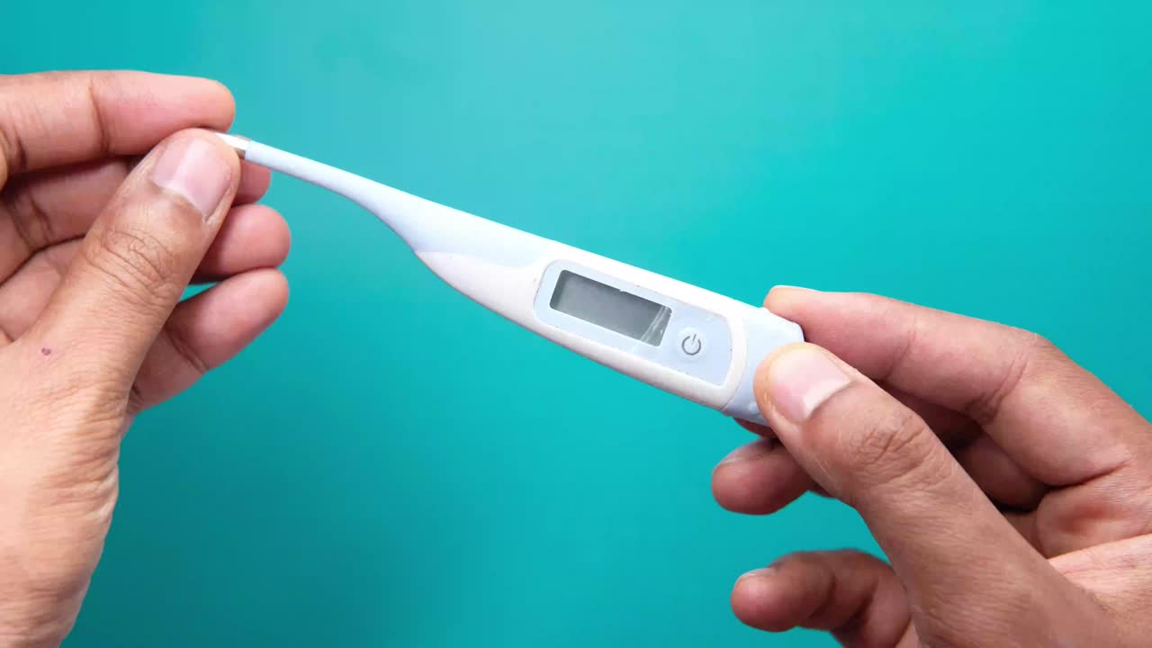 디지털 온도계를 들고 있는 사람