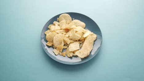 recogiendo a mano patatas fritas de un plato