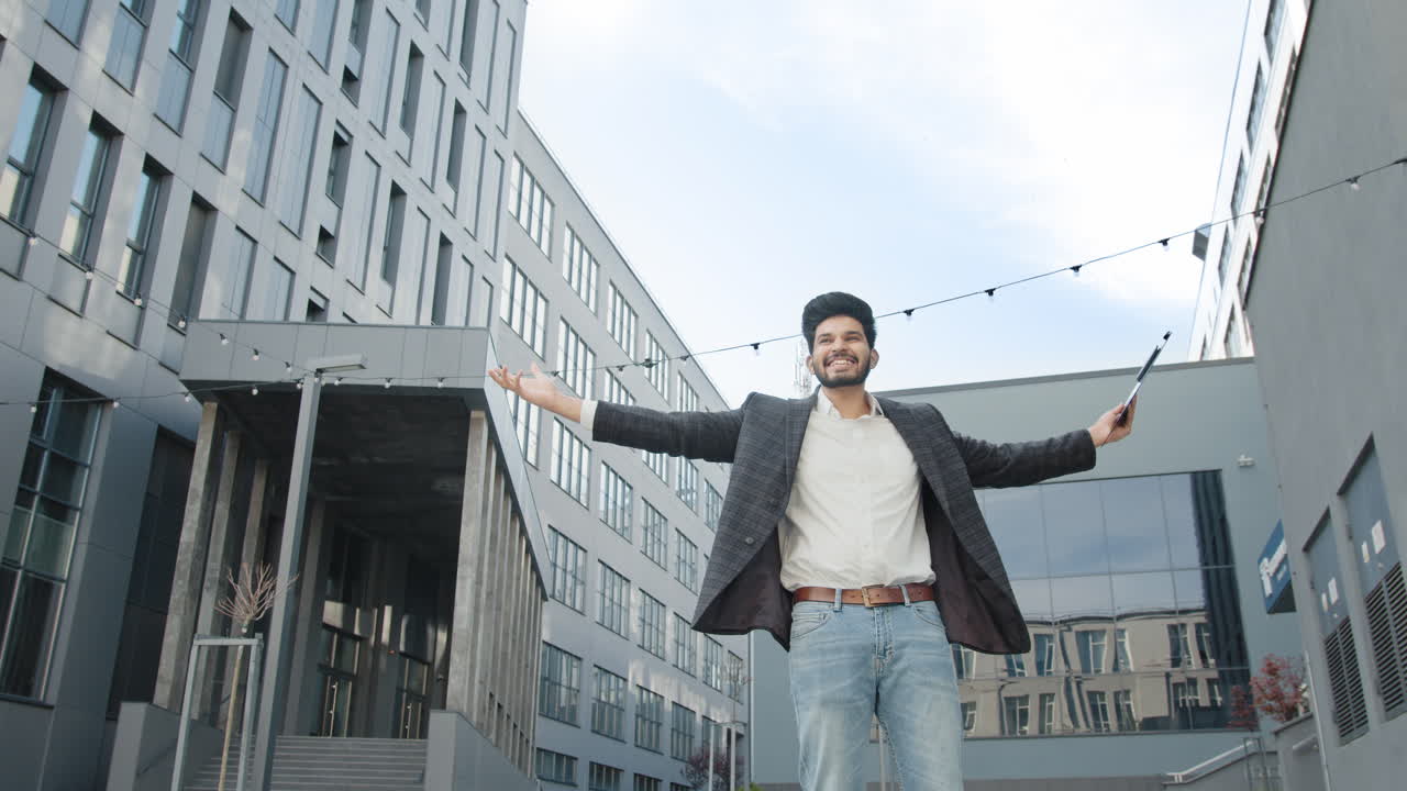 un hombre de negocios feliz celebrando el éxito al aire libre.