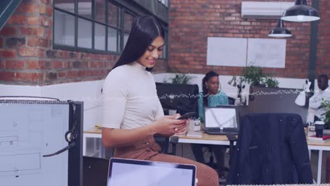 Animation-of-data-processing-over-biracial-woman-using-a-smartphone-at-office