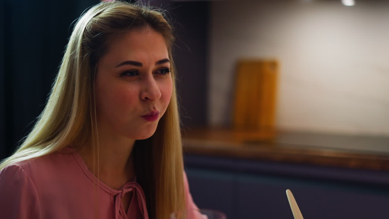 Lady coquettishly looks at friend eating salad at dinner