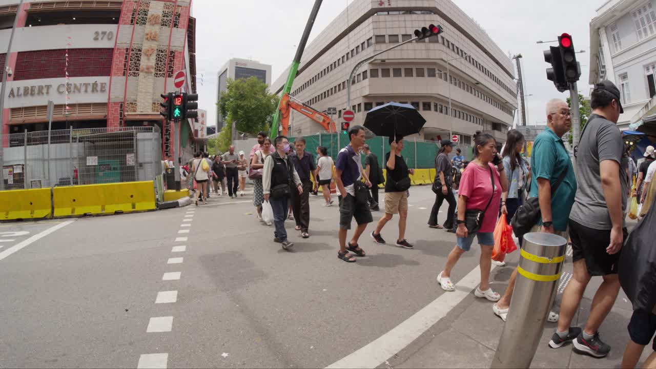Crowds of people strolling along Bugis Road in central Singapore