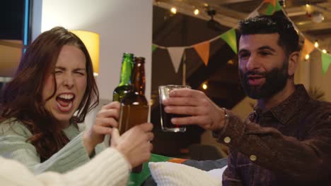 close up of group of friends at home or in bar celebrating at st patrick's day party drinking alcohol and doing cheers 2