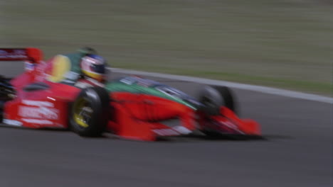 a racing car races around a track as people watch