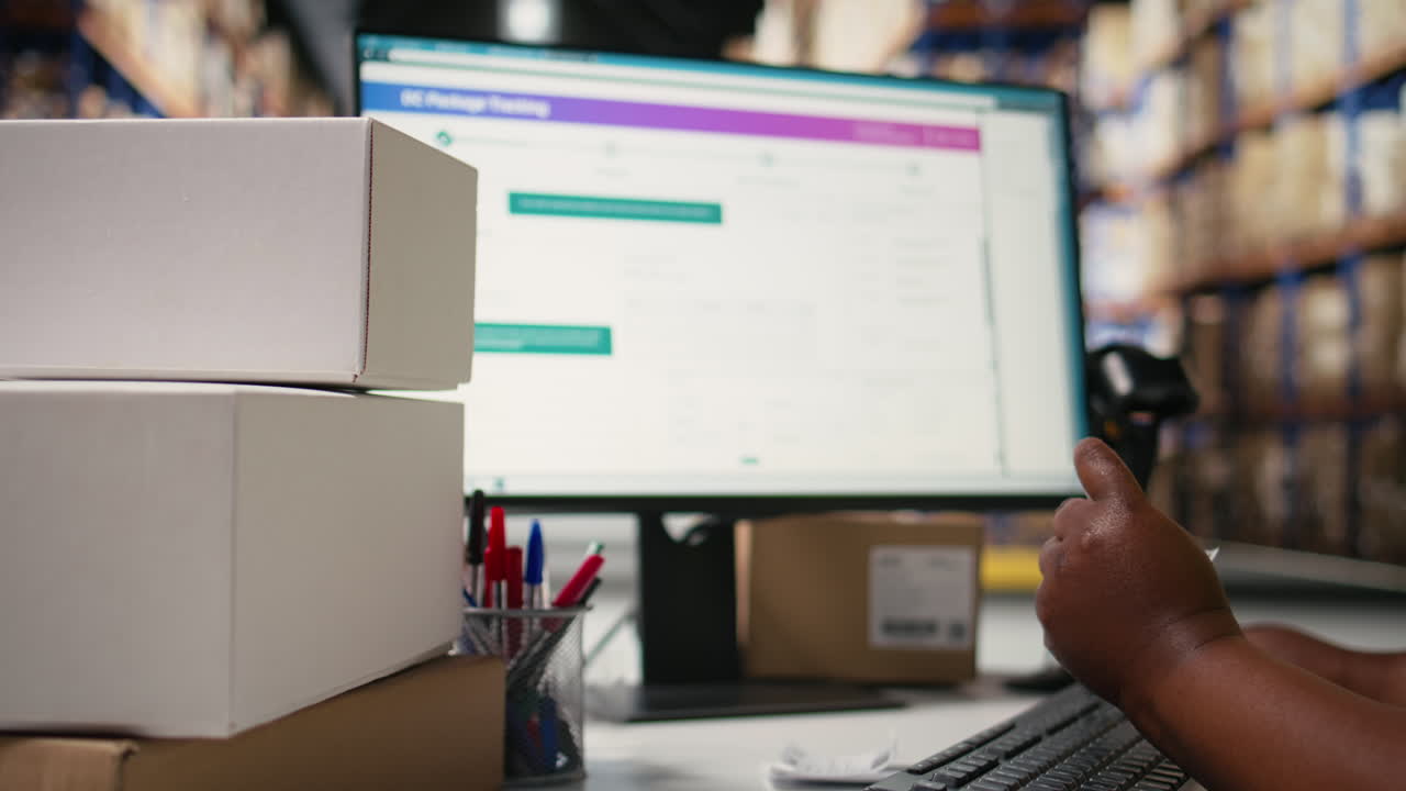 Female logistics worker sticking shipping labels on cardboard boxes