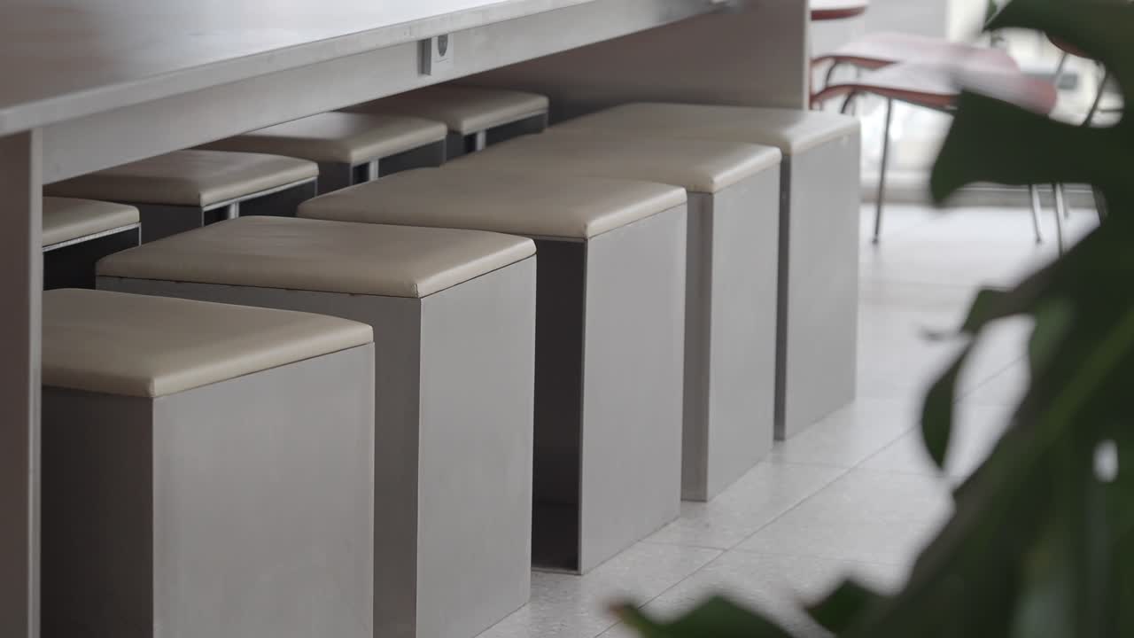 Interni di un moderno bar vuoto con sgabelli e tavoli grigi