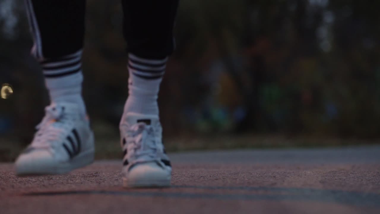Ground level close-up of a man's feet running on a path