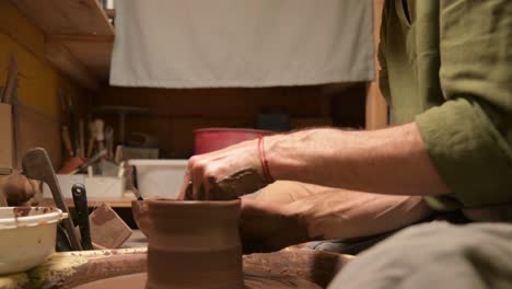 male hands making a clay bowl on a potter's wheel. handicraft and production of exclusive tea ware made of clay