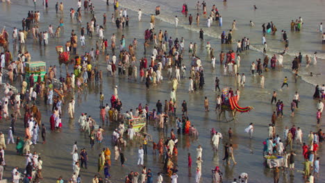 vista aérea de la playa con vista al mar en karachi, pakistán, cientos de personas están juntas para disfrutar, hermosos rayos de sol en las olas del mar
