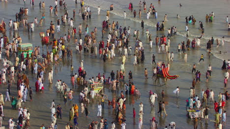 aerial view over the sea view beach at karachi pakistan, hundreds of people are together to enjoy, beautiful sun rays on the waves of sea