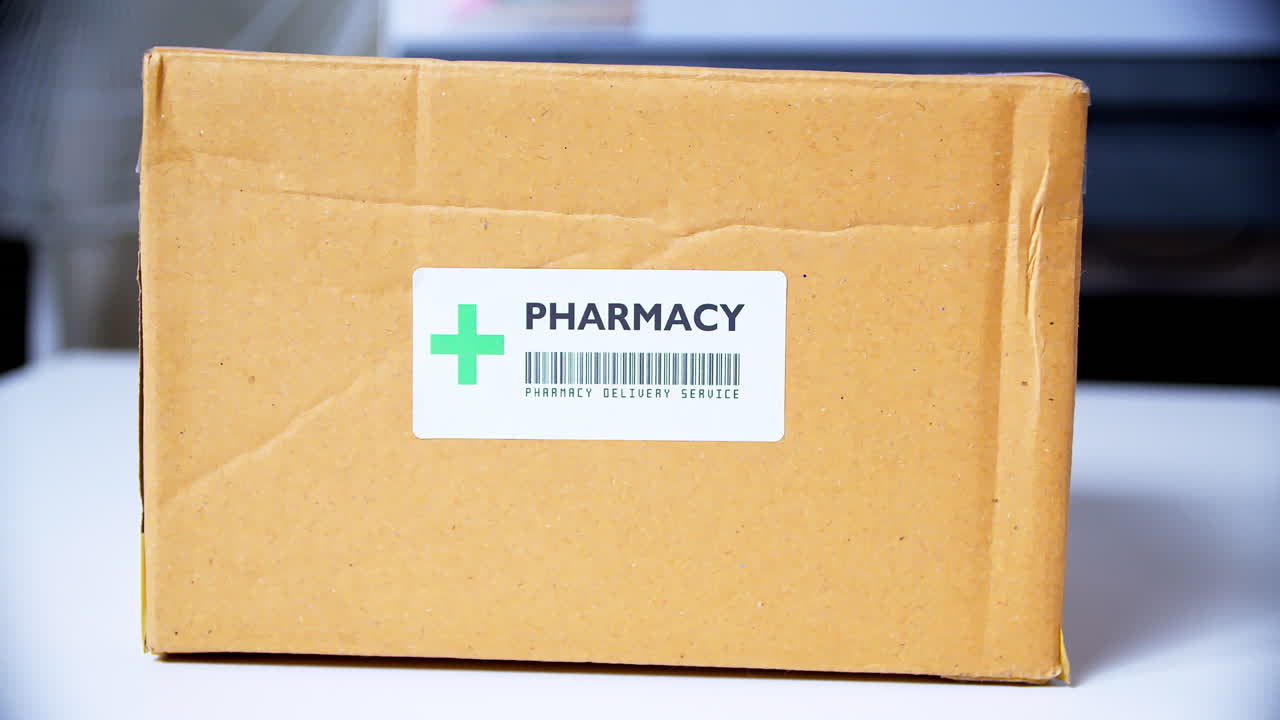 배송 골판지 상자에 +약국 스티커 라벨을 붙이는 손