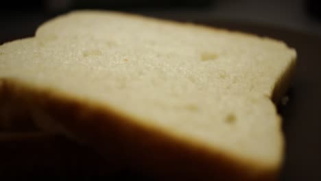 Una-Toma-De-Pan-Alrededor-De-Dos-Piezas-De-Pan-Blanco-En-Un-Plato