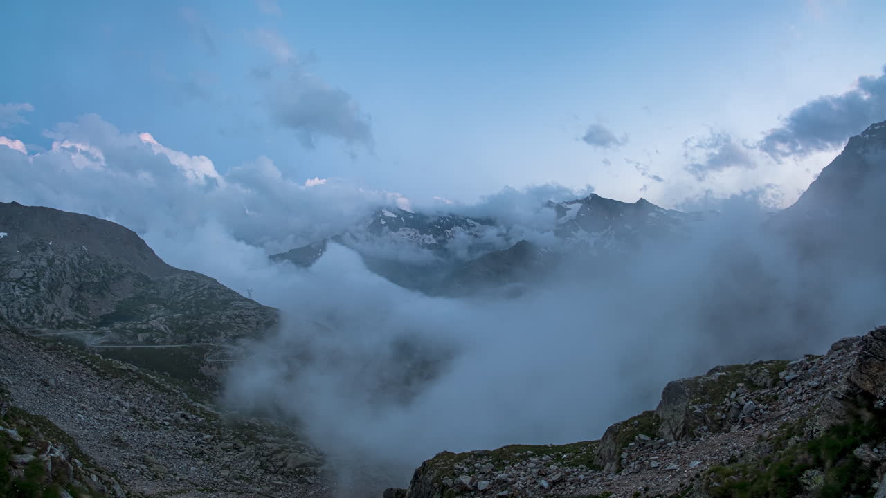 majestuoso lapso de tiempo de nubes girando sobre el paso del colle del nivolet, con picos de montañas y luz del anochecer