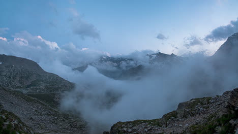 Majestic-timelapse-of-clouds-swirling-over-the-Colle-del-Nivolet-pass,-with-mountain-peaks-and-dusk-light