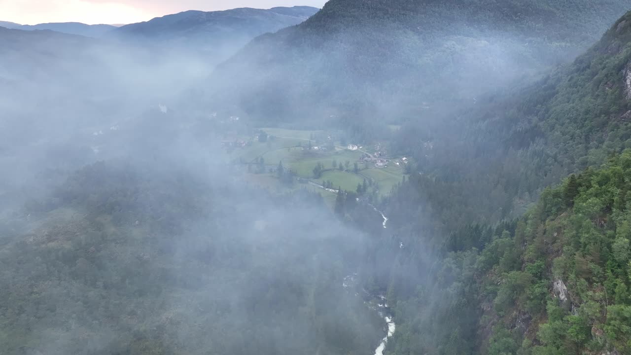 A local valley is filled with smoke after devastating forest fires in the area - Oyane stamneshella in western Norway - Forward moving aerial through a carpet of smoke