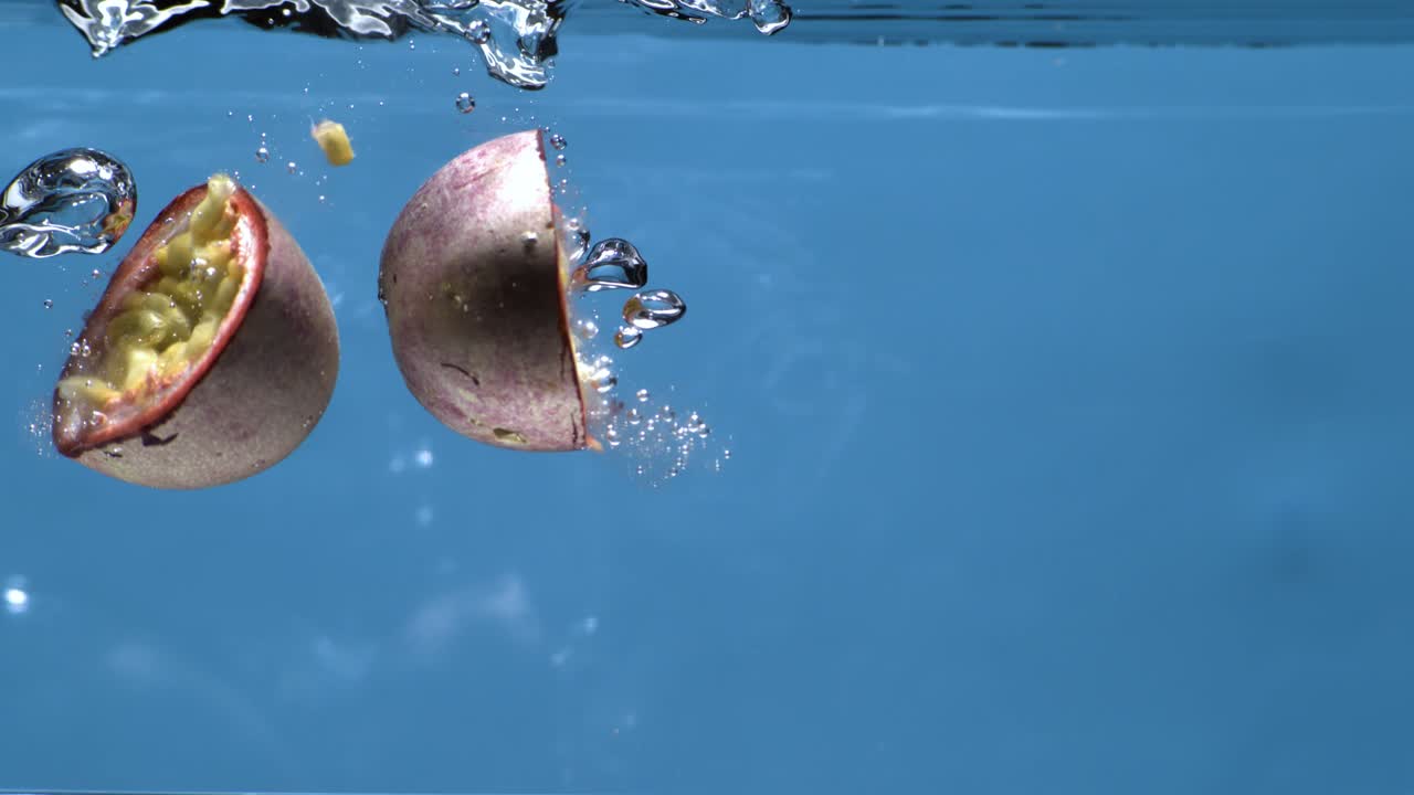 la fruta de la pasión cayendo en el agua en cámara súper lenta 1000fps