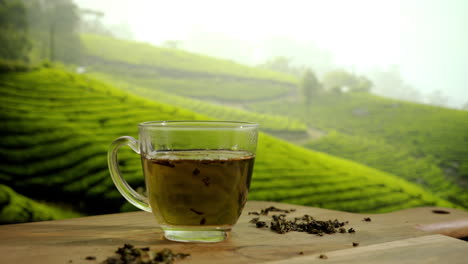 Dropping-green-tea-leaf-into-teapot-on-a-wooden-table