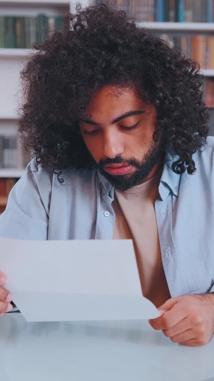 Un momento pensieroso: un uomo che legge una lettera in un accogliente ambiente di biblioteca.