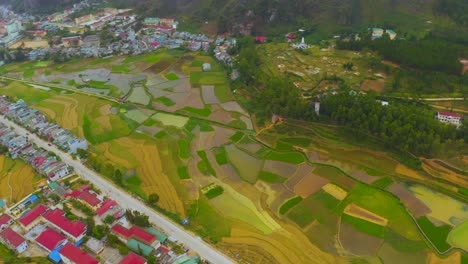 toma aérea de arriba hacia abajo de empanadas de arroz a lo largo de un río que conduce a la ciudad de dong van, en el geoparque de la meseta de karst de dong van