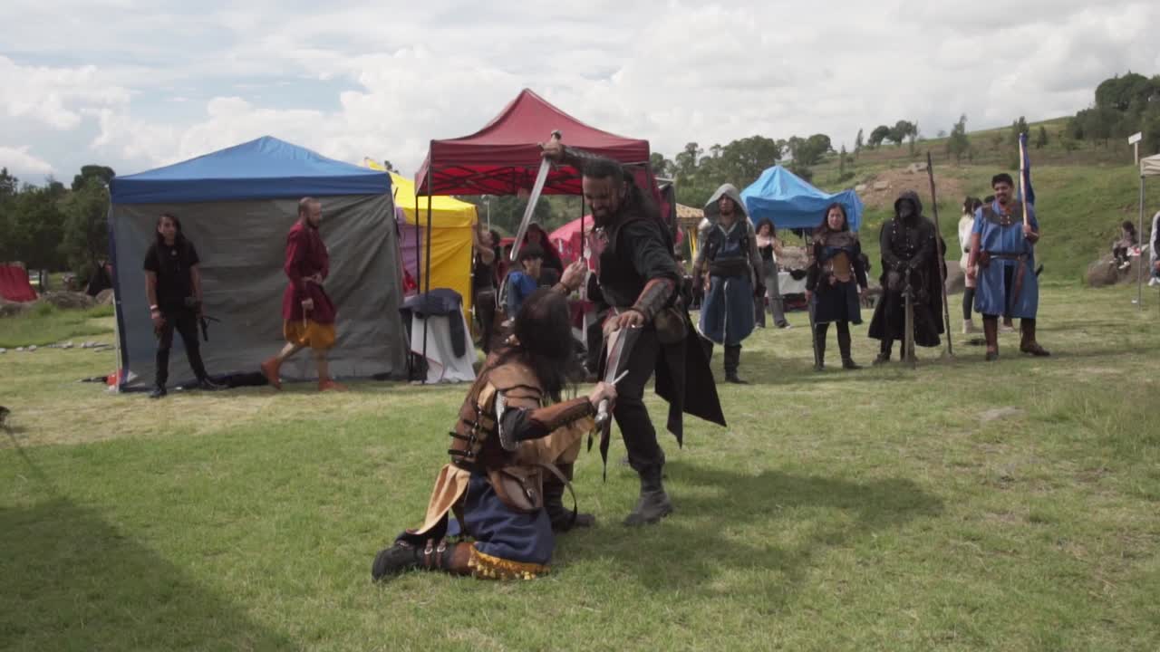Two warriors fighting with swords at a medieval event. Slow motion