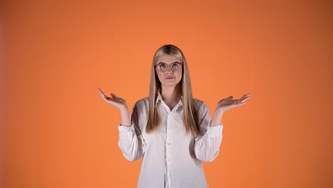 blonde girl unsure uncertain and doubtful, shrugging and arms hands gesture, colorful studio shot