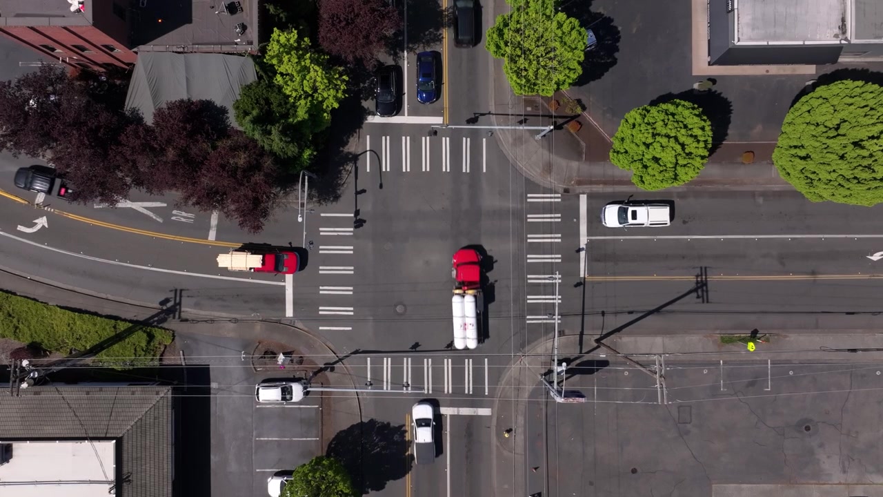 Top-down View Of A Busy Urban Intersection With Marked Crosswalk In Downtown Puyallup, Washington, USA. Aerial Shot