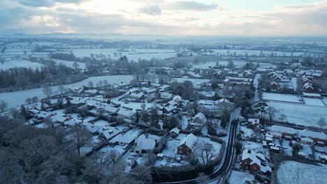 a charming english village from above, with frosty fields, snowy cottages, and crisp morning sunlight.