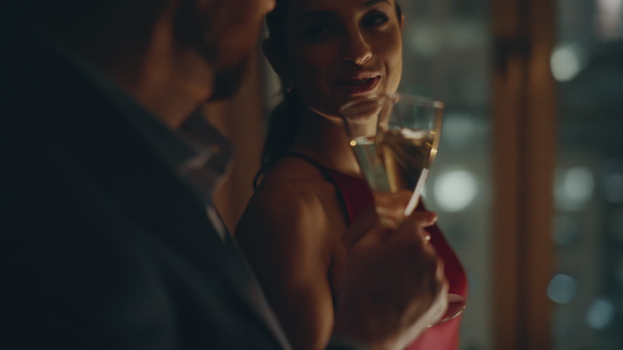 pareja de noche bebiendo champán celebrando el aniversario en el primer plano de la ventana oscura