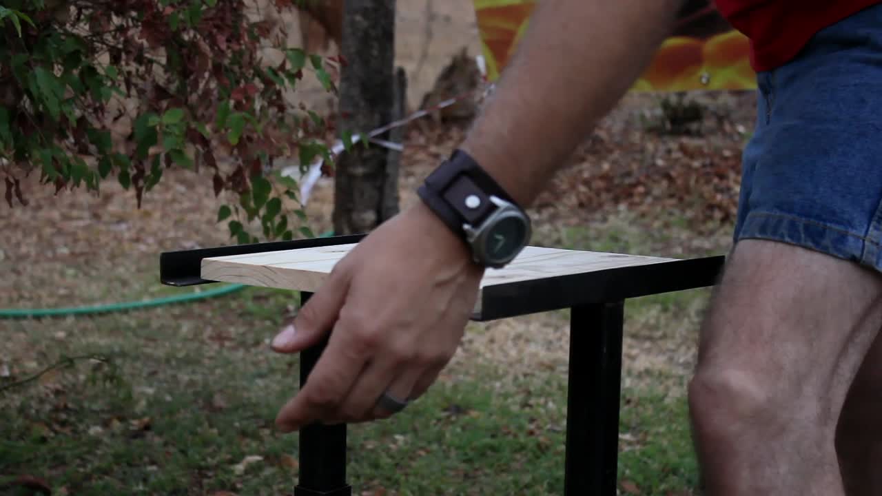 Man preparing to break wooden board. Lifting his hand up - down as preparation before he finally breaks the board.