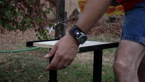 man preparing to break wooden board. lifting his hand up - down as preparation before he finally breaks the board.