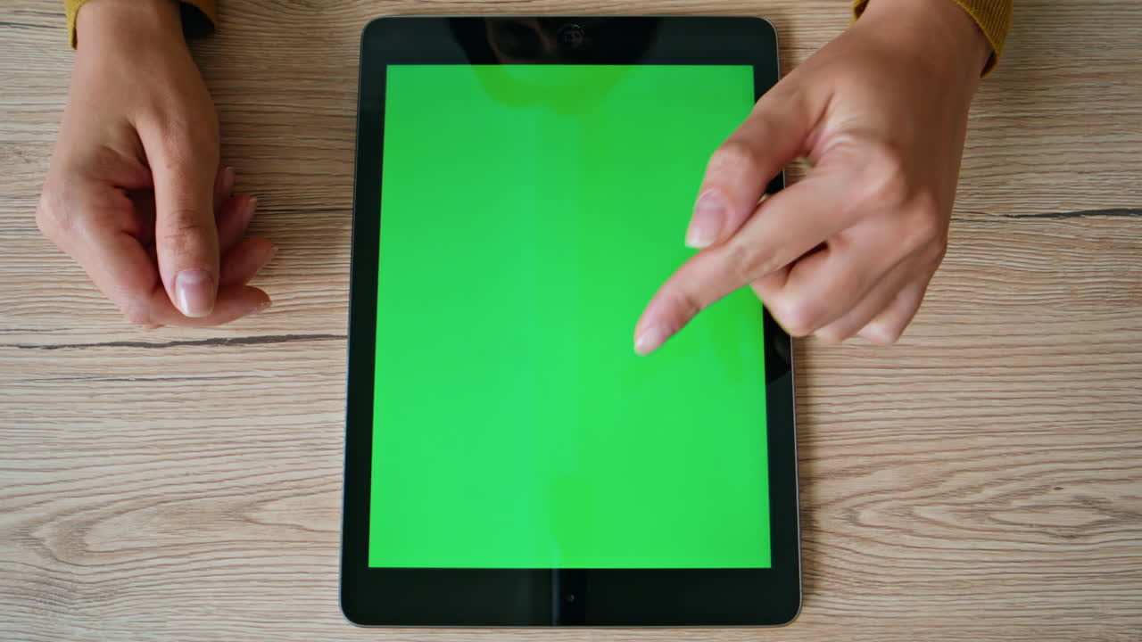 Freelancer working chromakey tablet at home desk closeup top. Woman touching