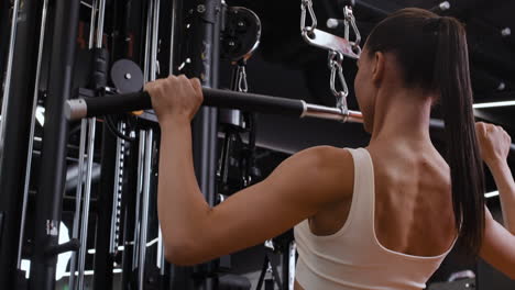 woman performing lat pulldown exercise in gym