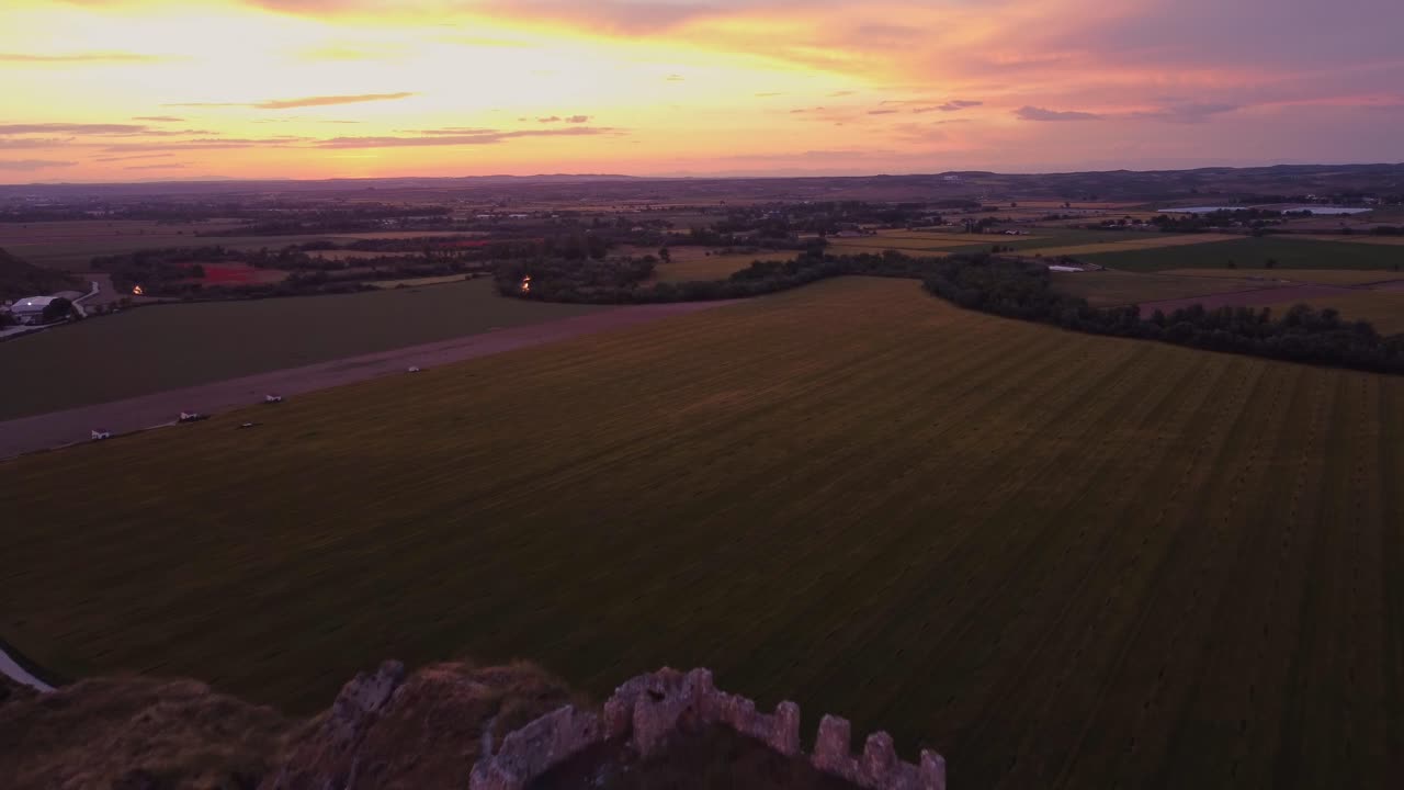 Ripresa drone del castello medievale di Oreja arroccato su una collina all'ora d'oro vicino ad Aranjuez, Spagna. Tramonto panoramico su campi rurali e paesaggio roccioso.