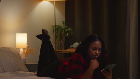 Woman Using Phone in Bed at Night