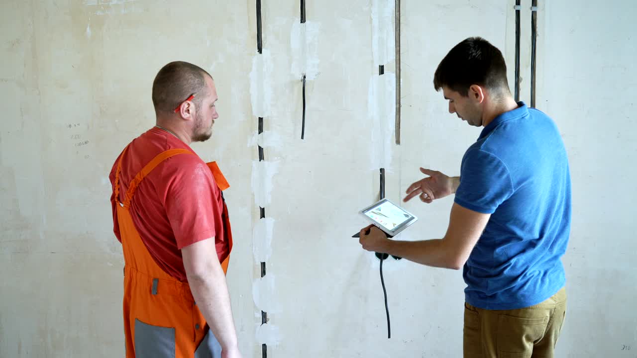 ingeniero y arquitecto discutiendo a través de una tableta inalámbrica digital trabajando en el sitio de construcción interior