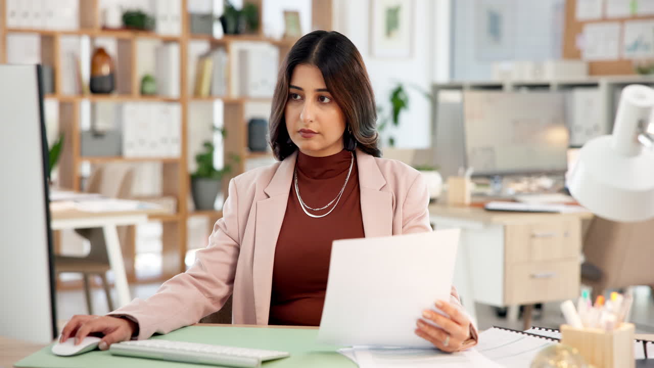 Donna professionista che lavora al computer ed esamina documenti in ufficio